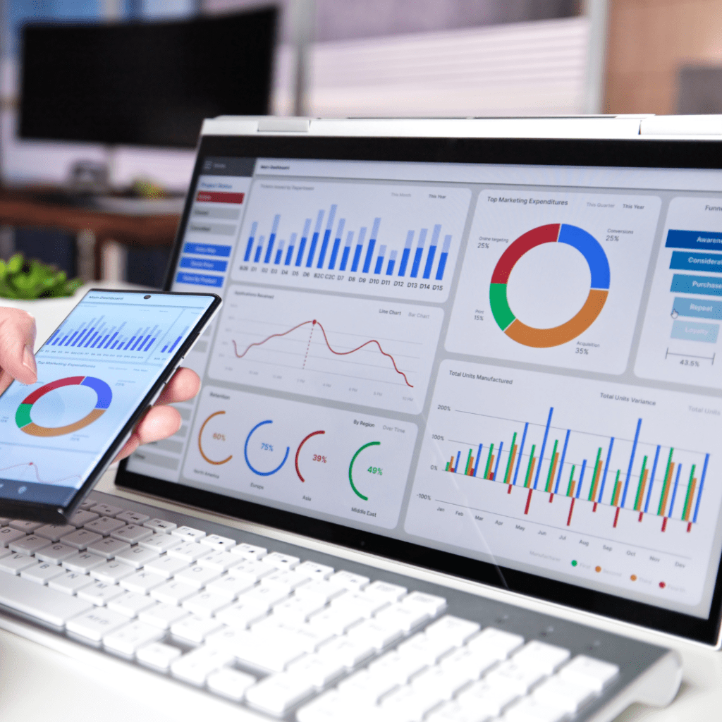 Laptop and smartphone syncing digital marketing data analytics dashboards